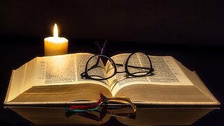 Buch mit Kerze und Brille