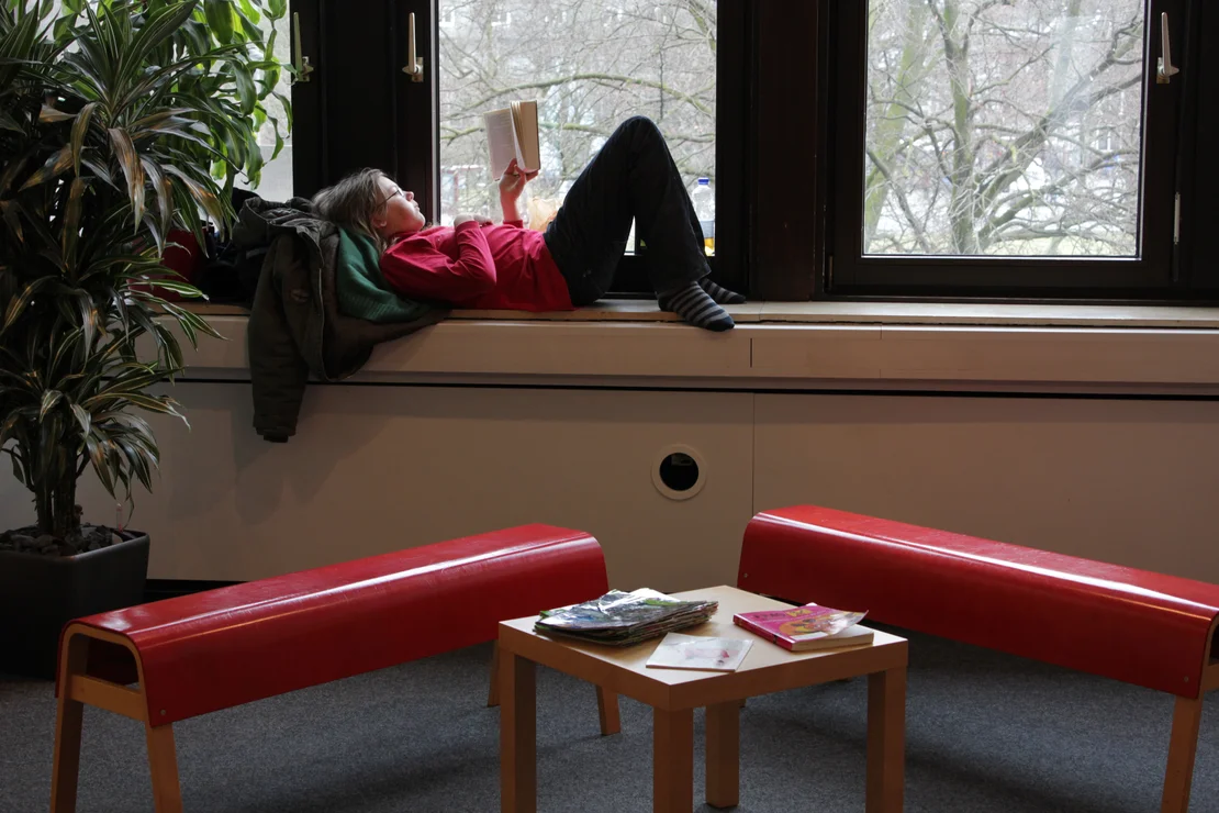 Kind auf Fensterbank Lesen kann man überall
