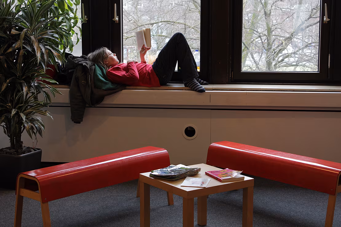 Kind auf Fensterbank Lesen kann man überall