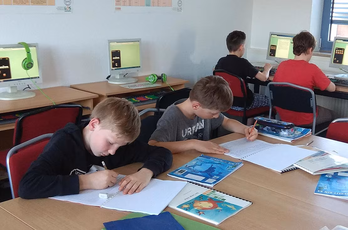 Kinder arbeiten am PC und im LOS-Lehrmaterial im LOS Wuppertal