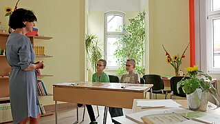 Zwei Jungen sitzen an einem Tisch und hören einer Frau zu. | Bildrechte: MDR WISSEN, Torsten Backofen, Daniel Berg Zwei Jungen sitzen an einem Tisch und hören einer Frau zu. | Bildrechte: MDR WISSEN, Torsten Backofen, Daniel Berg